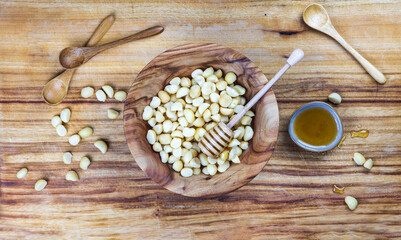 macadamia and honey on wooden background
