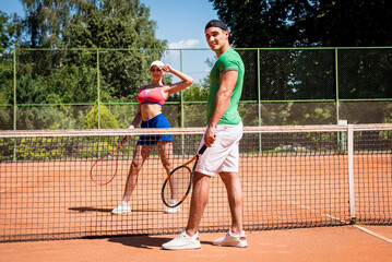 Young athletic couple playing tennis on the court.