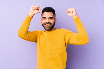 Young mixed race arabic man isolated celebrating a special day, jumps and raise arms with energy.