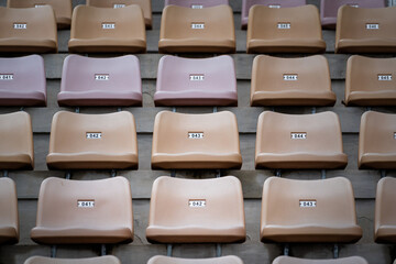 A row of yellow seating chair in sport stadium, close-up and selective focus. Sport object/background pattern photo.