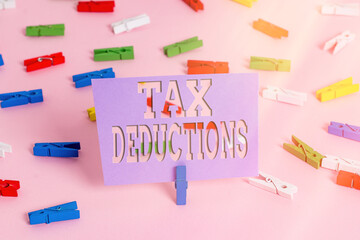 Handwriting text writing Tax Deductions. Conceptual photo an amount or cost that subtracted from someone s is income Colored clothespin papers empty reminder pink floor background office pin
