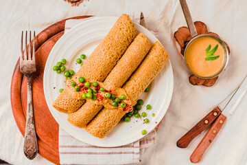 Homemade Coconut flour and turmeric keto wraps with cottage cheese sauce. Low-carb gluten free crepe with curry sauce and sweet corn and green peas on top