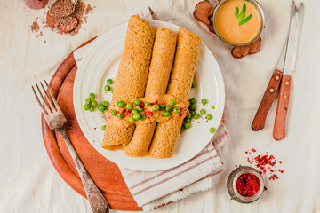 Homemade Coconut flour and turmeric keto wraps with cottage cheese sauce. Low-carb gluten free crepe with curry sauce and sweet corn and green peas on top