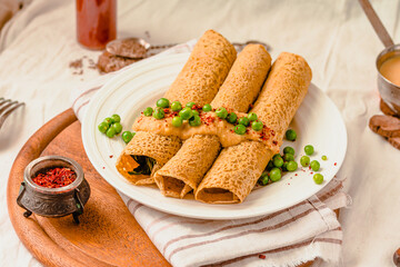 Gluten-free keto Crepes filled with Spinach.in the oven with curry sauce and sweet corn and green peas on top