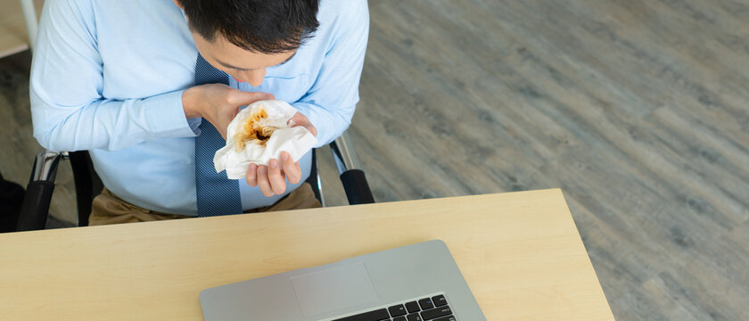young asian businessman geeting hematemesis in the office because of working hard