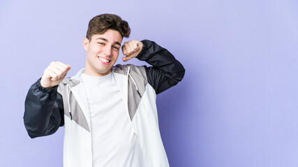 Young caucasian man isolated on purple background stretching arms, relaxed position.