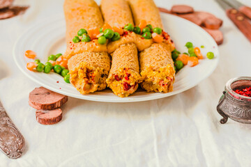 Gluten-free keto Crepes filled with paprika hummus in the oven with curry sauce and sweet corn and green peas on top