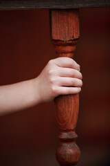 Close-up of children's hands and balusters at the porch