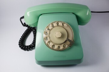 Telephone with old dialer. Green color and white background