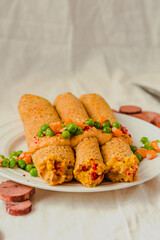 Gluten-free keto Crepes filled with paprika hummus in the oven with curry sauce and sweet corn and green peas on top