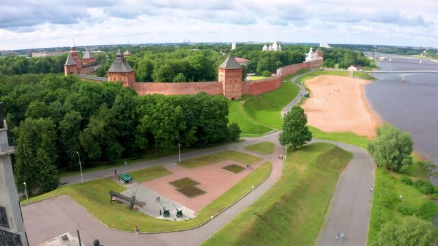 Panoramic aerial view of the Volkhov River and the old town of Veliky Novgorod, the red brick Kremlin in the rays of the setting sun and natural attractions of Russia.