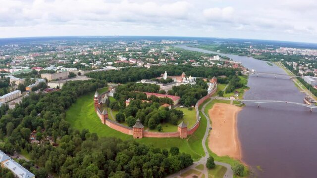 Panoramic aerial view of the Volkhov River and the old town of Veliky Novgorod, the red brick Kremlin in the rays of the setting sun and natural attractions of Russia.