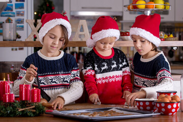 Happy children, boy brothers, baking christmas cookies at home