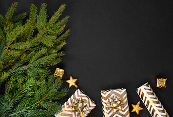 Christmas decoration on dark background. Shiny golden Christmas gifts and golden decorations on black background. Flat lay composition for new year, xmas, christmas.