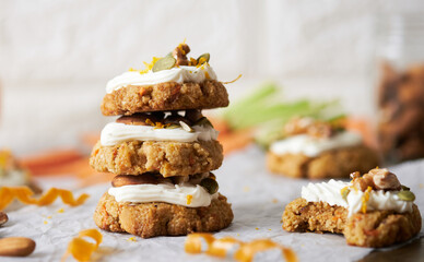 Keto Carrot oatmeal cookies. Healthy homemade ketogenic diet dessert decorated with white cream, nut and seeds. set on white cafe table background.