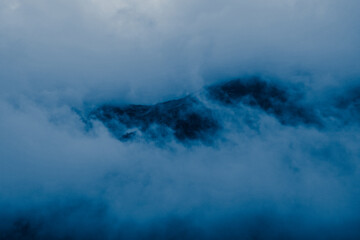 Fog and clouds in mountains backdrop.