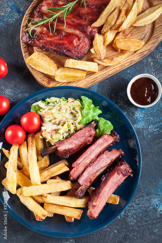 Wall mural Spicy barbecued pork ribs served with french fries