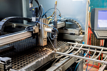 The laser cutting machine cutting the holes on pipes
