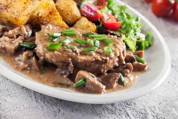 Pork loin chop with mushroom sauce and baked potatoes