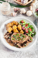 Pork loin chop with mushroom sauce and baked potatoes