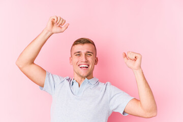 Young caucasian man isolated celebrating a special day, jumps and raise arms with energy.