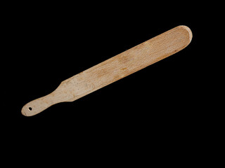 Espátula de madera para cocinar, sobre fondo negro.