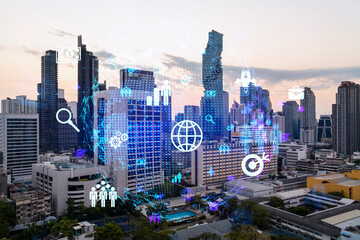 Obraz premium Hologram of social media icons over sunset panoramic cityscape of Bangkok, Asia. The concept of people connections. Multi exposure.
