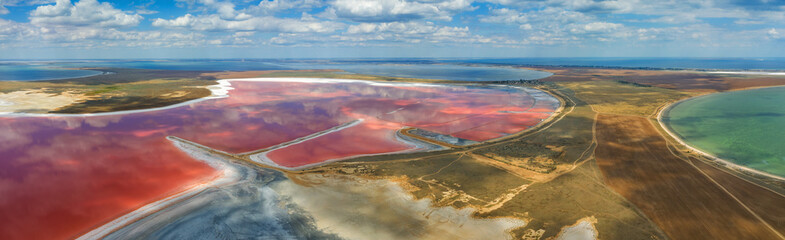 aerial panoramic view to the coast with sea side and pink lake under clouds in Ukraine