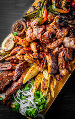 Assorted Mixed different grilled meat with vegetables on table