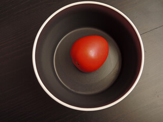 red tomato in a black plate.
