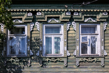 Vintage architecture facade old wooden house. Gingerbread wooden white trims frame windows.