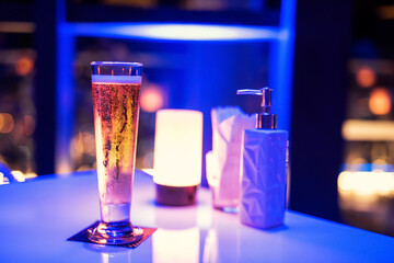 glass of  beer in luxury bar with night light bokeh