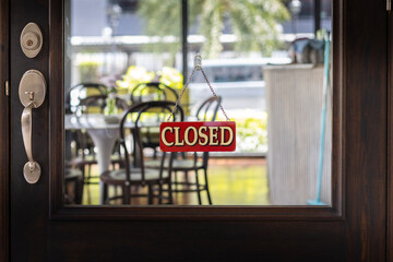 Closed sign board at shop window door, cafe restaurant out of business durring coronavirus (covid-19) crisis. Isolation, quarantine, and lockdown concept. US, UK.