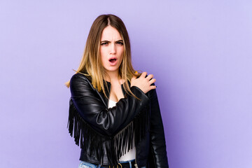 Young caucasian woman isolated on purple background having a shoulder pain.