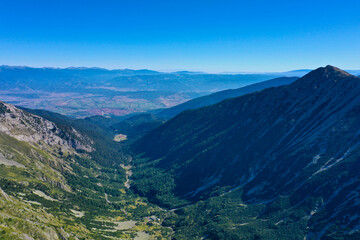 Mighty Balkan mountains peaks view, summer time, travelling and hiking motivation concept. Small old European village on the background.