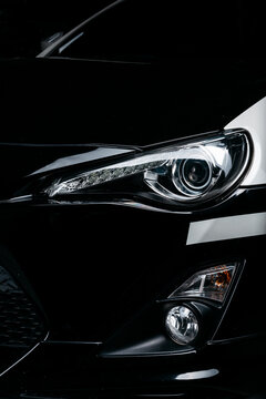 Fototapeta Car detailing series: Clean headlights of black sports car