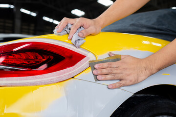 Auto body repair series: Wet sanding yellow sports car bumper