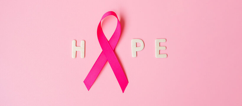 October Breast Cancer Awareness month, Pink Ribbon with HOPE text on pink background for supporting people living and illness. International Women, Mother and World cancer day concept