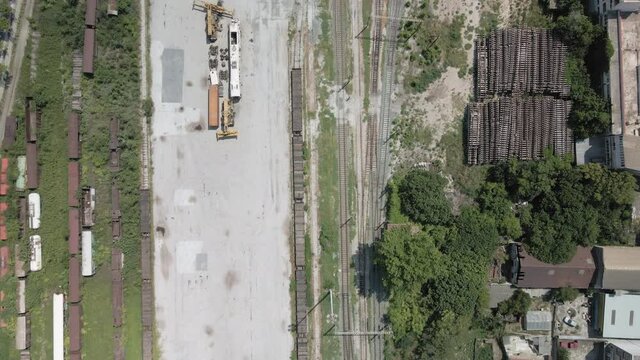 Aerial drone landscape view of train commercial wagons on railroad. Day top panorama of railway tracks with freight connected vehicles used for goods transport in Thessaloniki, Greece.