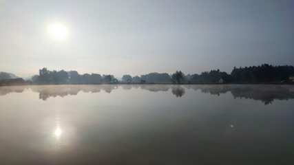 Fishing lake in the foggy morning