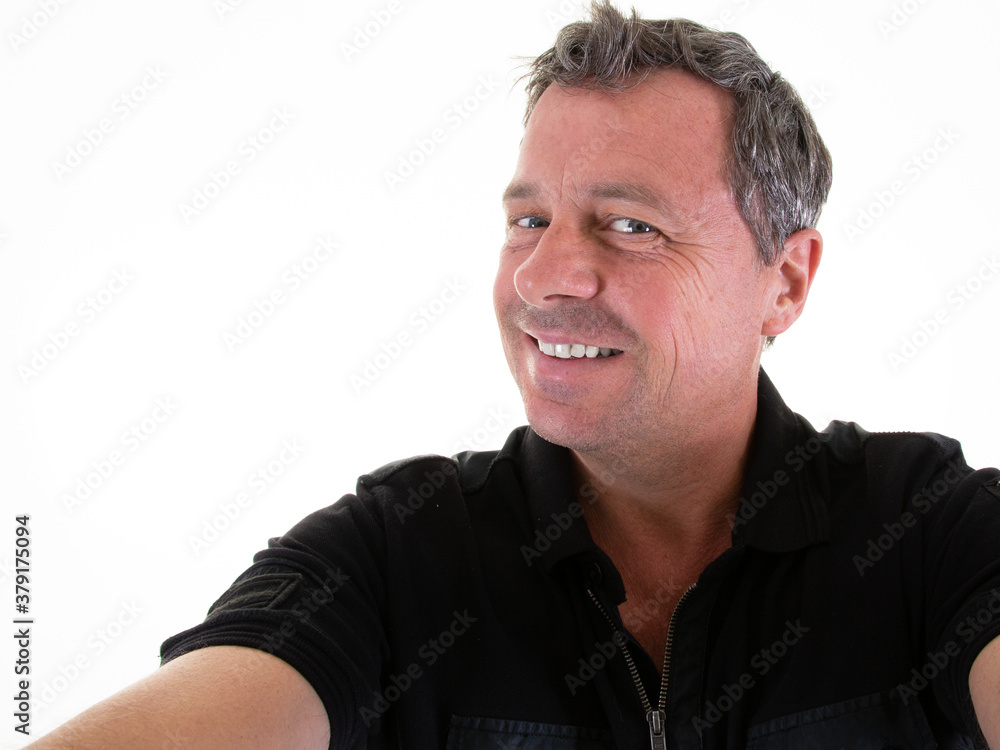 Wall mural happy handsome young male selfie smiling with toothy smile looking at the camera make self portrait 