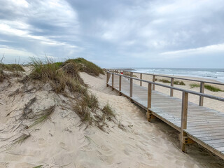 Boardwalk near the sand dunes in Costa Nova, Portugal with the ocean in the background