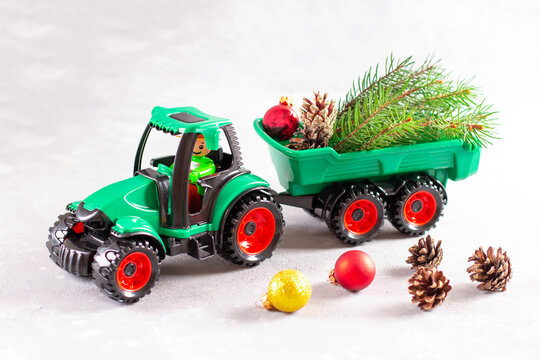Green tractor toy with fir branch, fir cone.