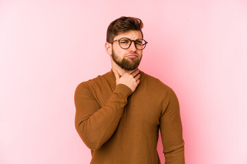Young caucasian man isolated on pink background suffers pain in throat due a virus or infection.