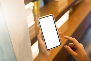 Woman hand's holding empty screen mobile phone at the cafe.