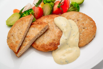 schnitzel, chicken cutlet with white sauce and vegetables