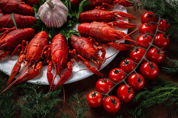 Crayfish on a plate with garlic cherry tomatoes chili peppers and parsley and dill