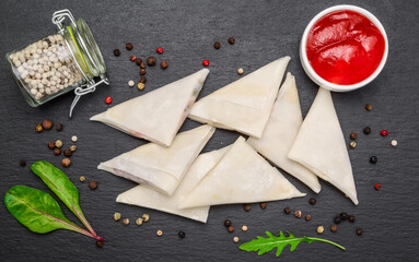 Envelopes of dough with toppings and spicy sauce. Aprefabricated frozen