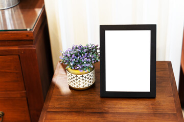 Empty white picture frame on the table.