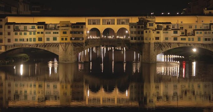 Close up of Ponte Vecchio during the night with the reflection on the Arno river